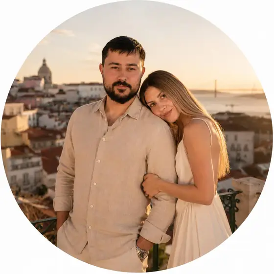Anatoly and Julia at a viewpoint above Alfama at sunset, the 25 de Abril Bridge behind them