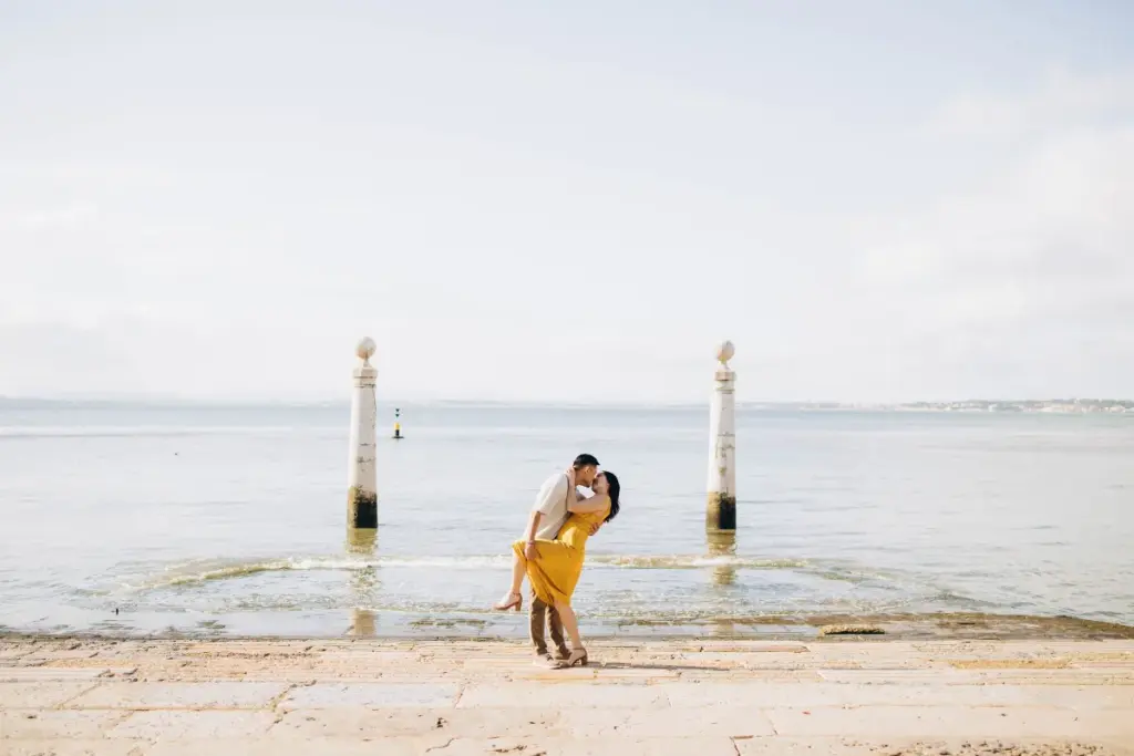 Couple kissing between the columns of Cais das Colunas on the Tagus