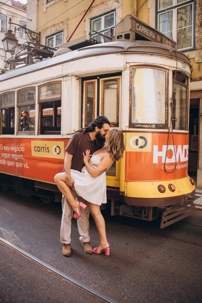 Couple kissing in front of a yellow tram