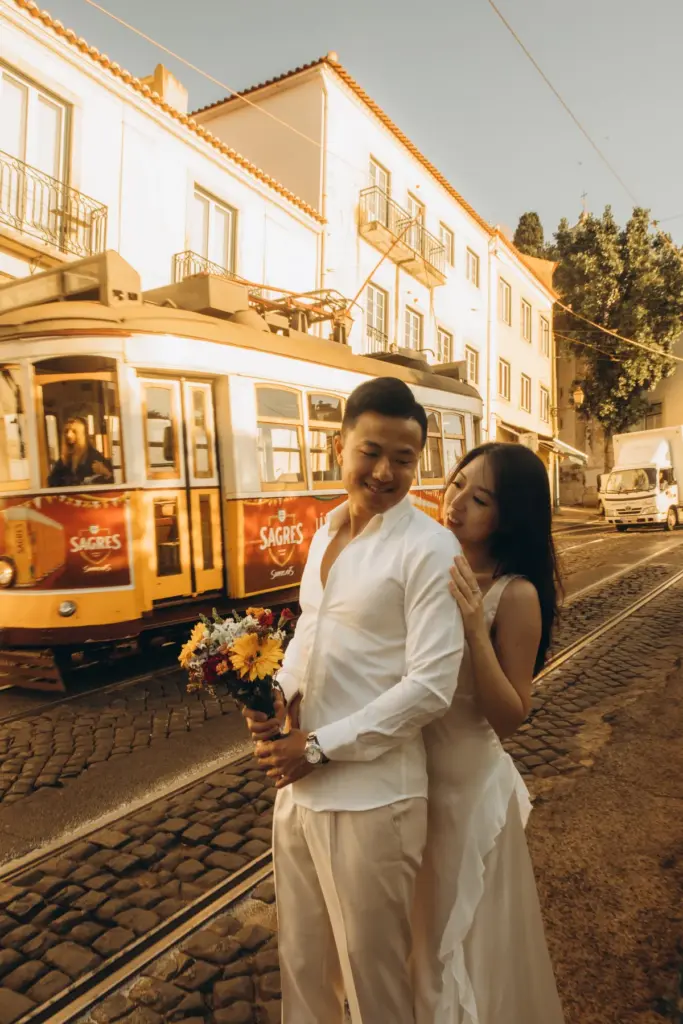 Couple with a bouquet beside a tram in Alfama