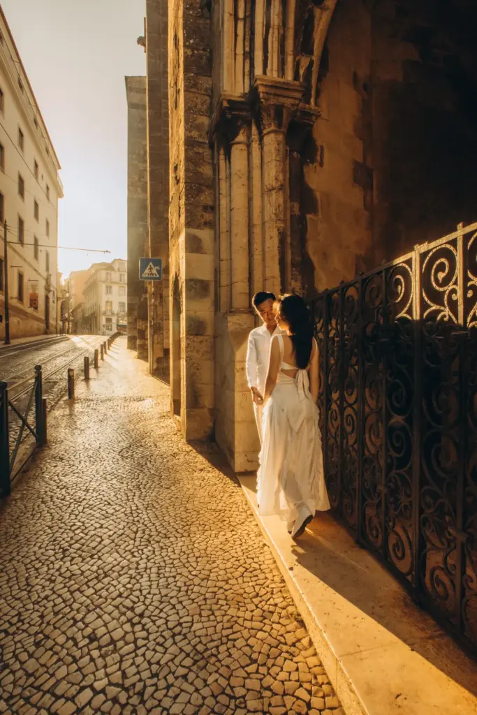 Couple embracing in a narrow cobbled street by Lisbon Cathedral