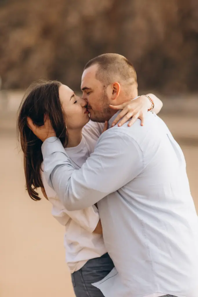 Couple embracing on the sand at Praia da Adraga