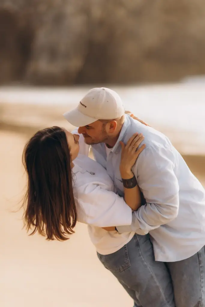 Couple kissing on the beach at Praia da Adraga