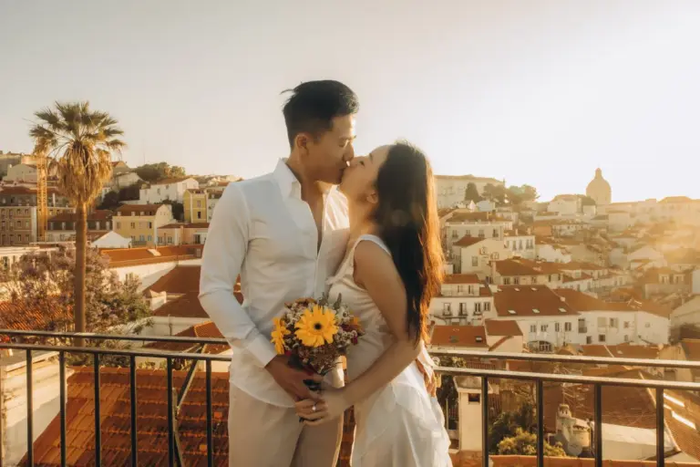 Couple kissing with a bouquet at an Alfama viewpoint