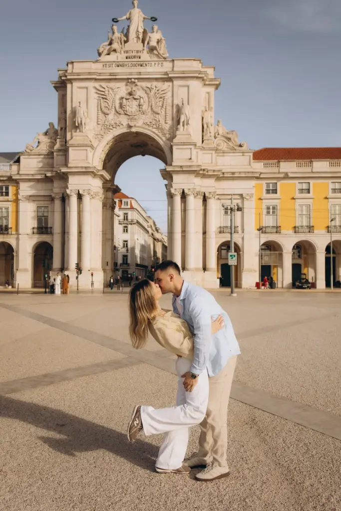 Couple kissing in front of the Rua Augusta Arch