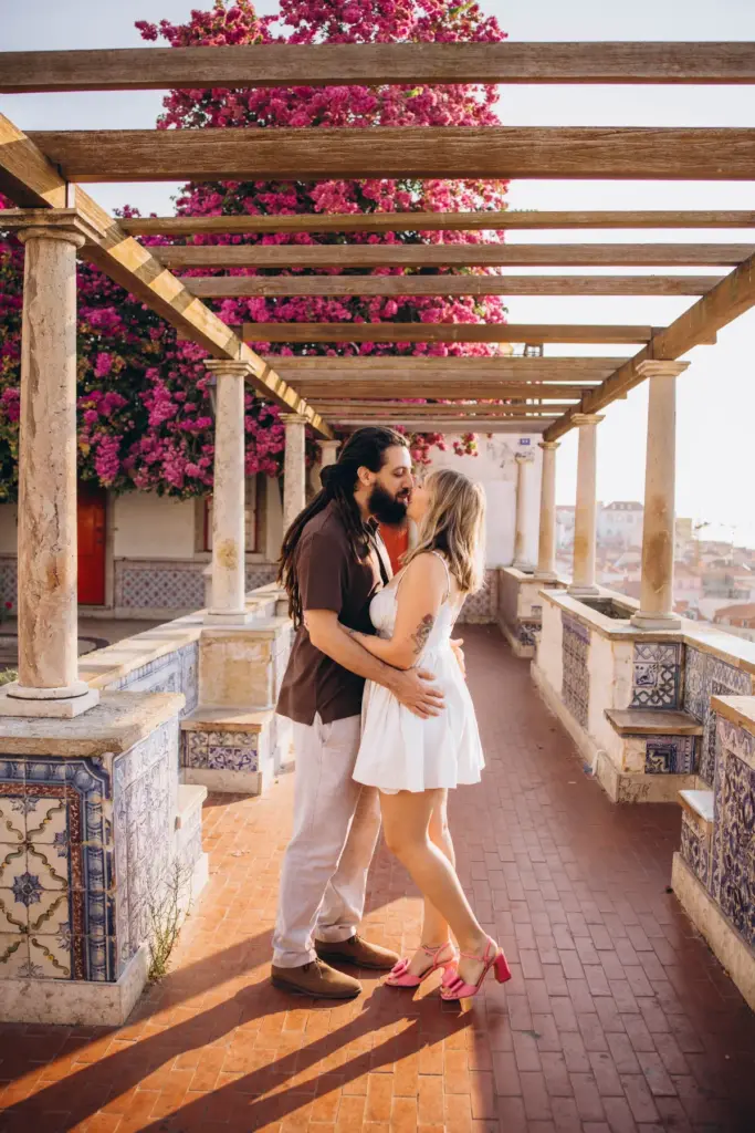 Couple kissing under the bougainvillea pergola at Santa Luzia