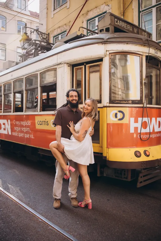 Man lifting his partner in front of a tram in Alfama
