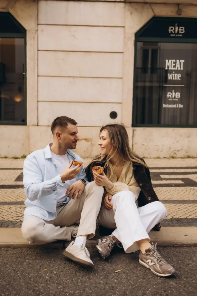 Couple sharing a pastry on the pavement in Baixa