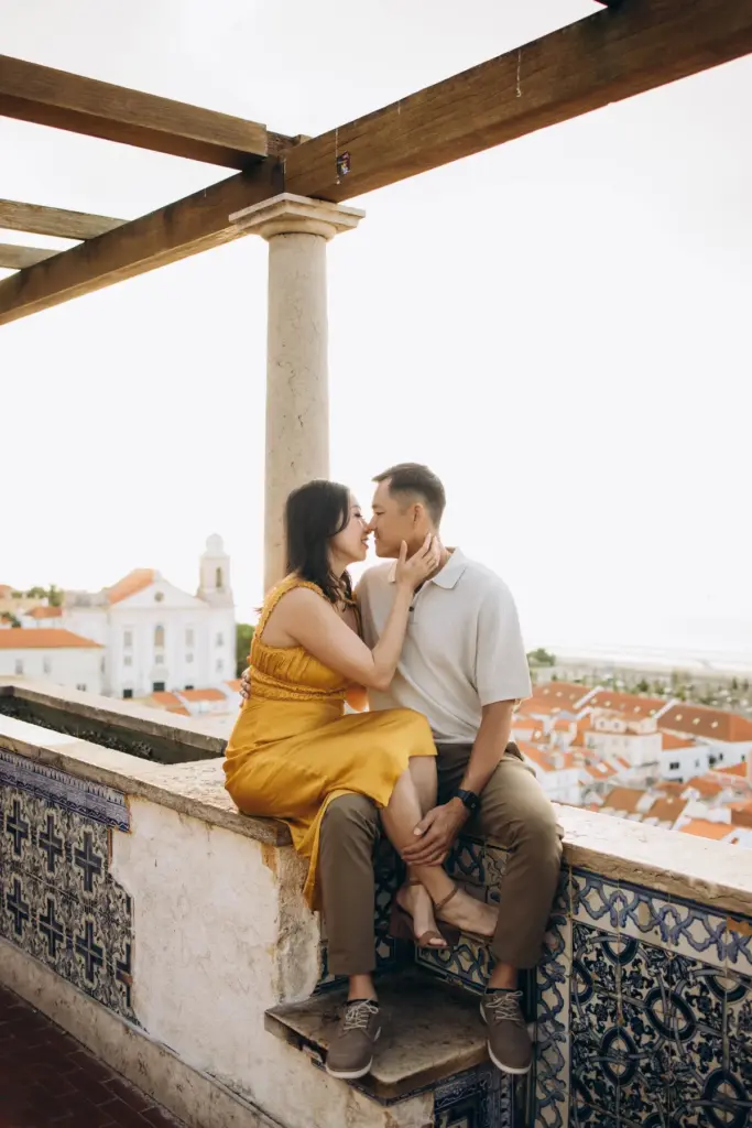 Couple sitting on the tiled wall under the pergola at Santa Luzia