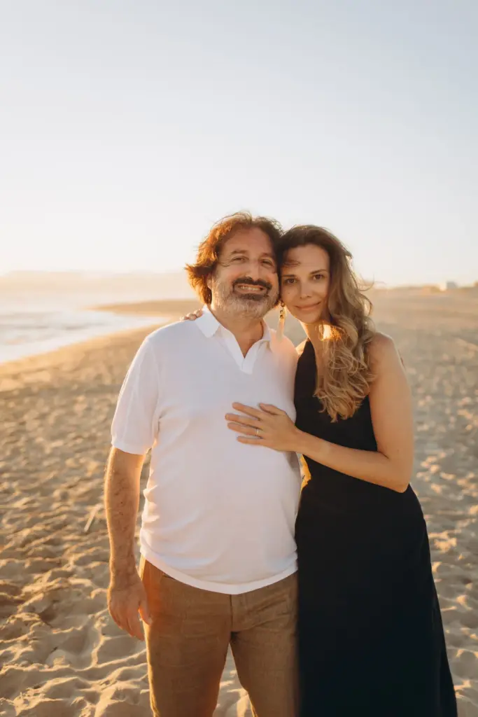 Couple smiling together on the sand at Costa da Caparica