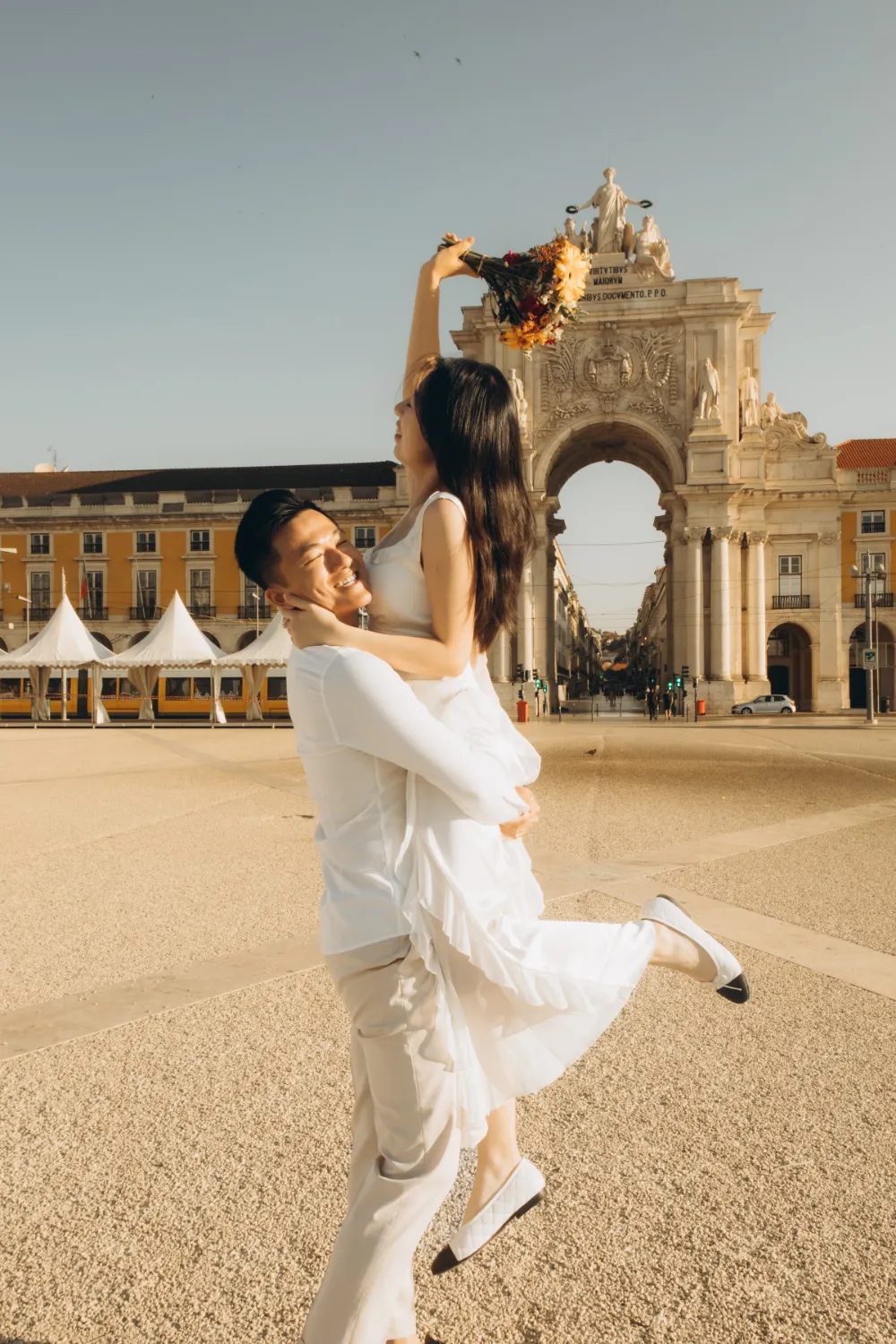 Couple spinning in Praça do Comércio at sunrise