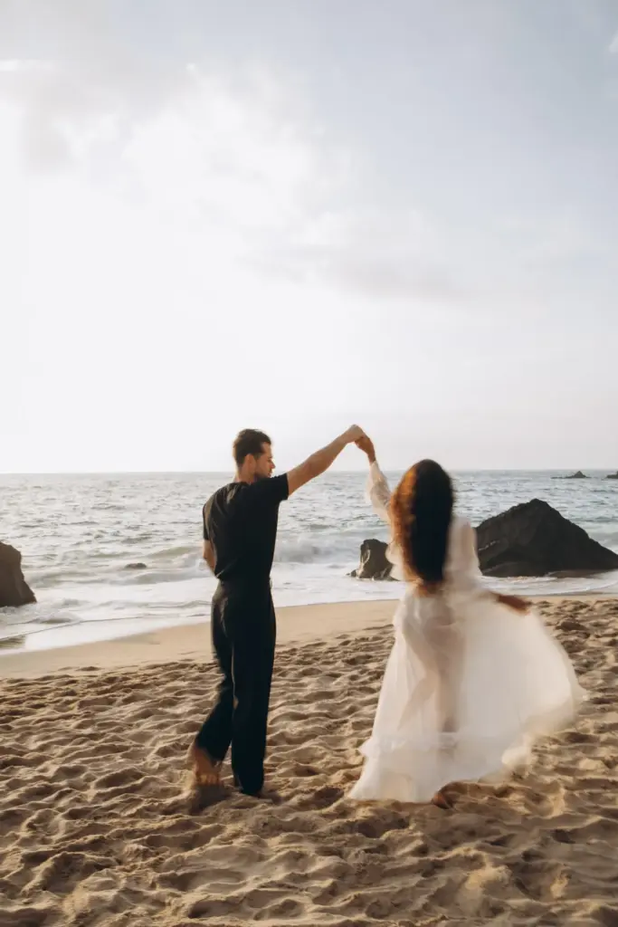 Couple twirling on the sand at Praia da Adraga