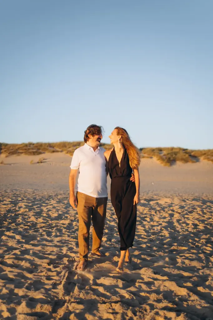 Couple walking towards the dunes at Costa da Caparica