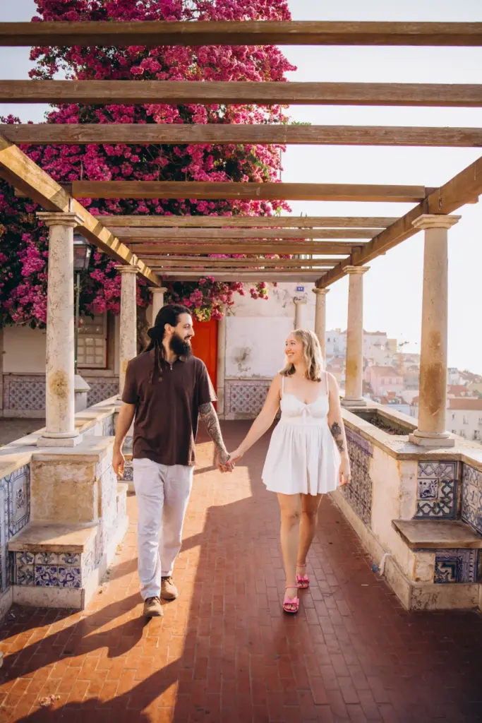 Couple walking under the bougainvillea pergola at Santa Luzia