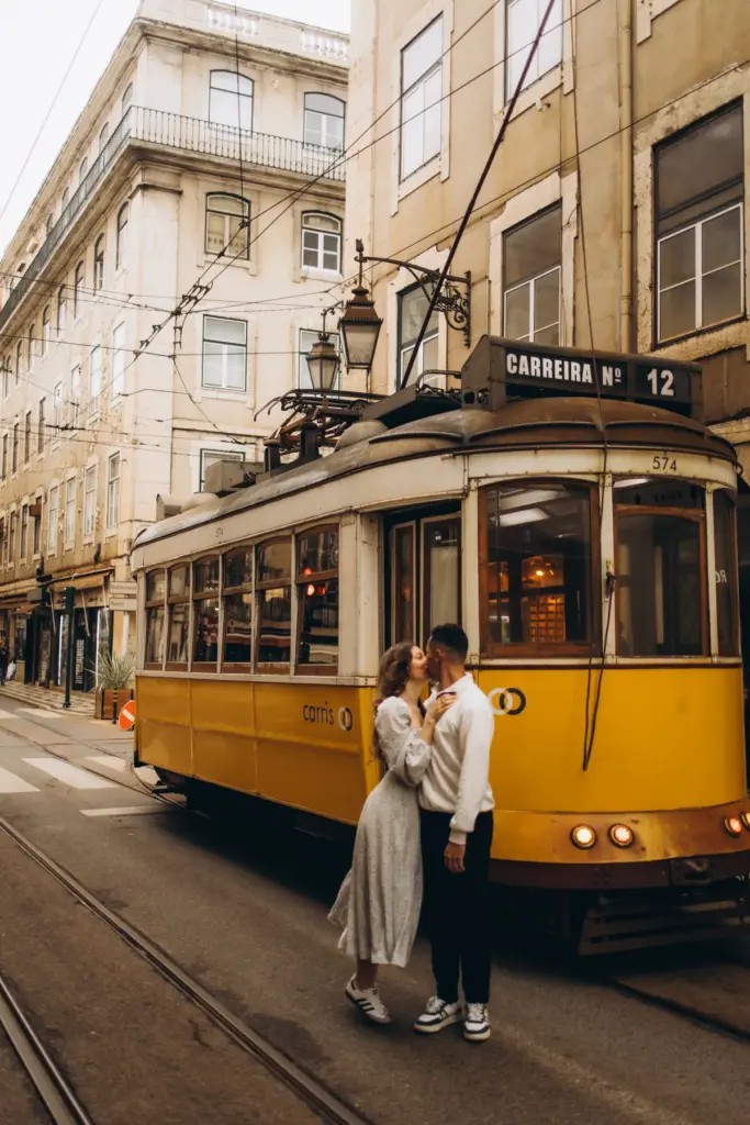 Couple beside a yellow tram in Lisbon