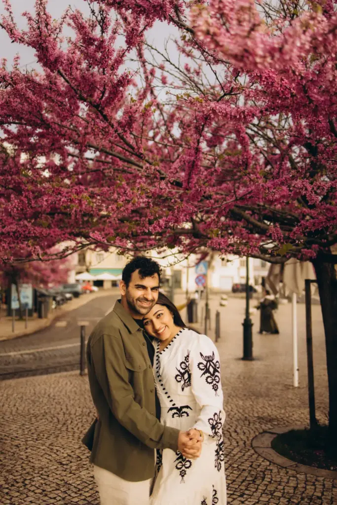 Couple under pink blossom on a Lisbon square