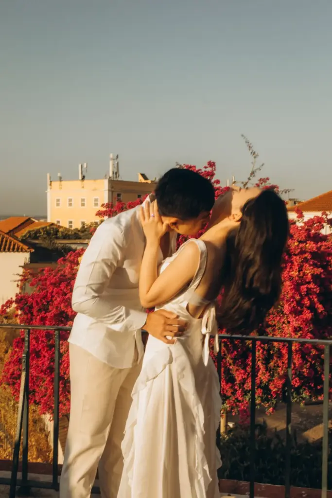Couple with a bouquet among red flowers above the river