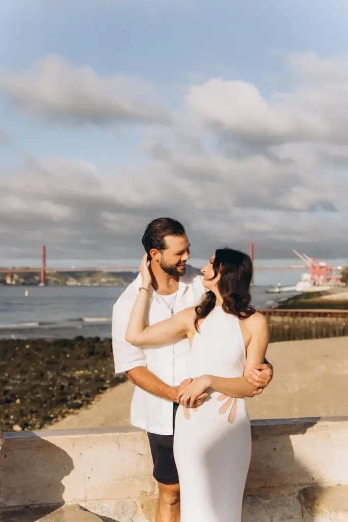 Engaged couple embracing by the Tagus