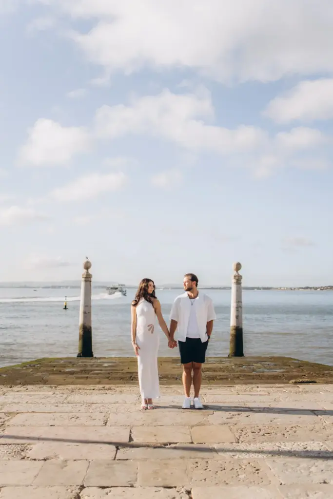 Engaged couple walking on the Cais das Colunas steps