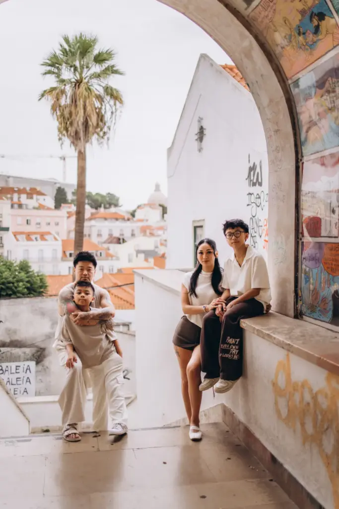Family on steps under an arch in Alfama
