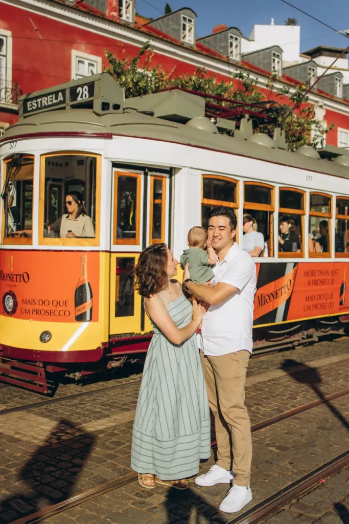 Family with a baby in front of tram 28 in Lisbon