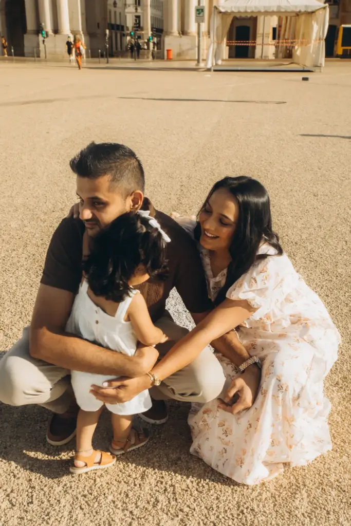 Family crouching together with their toddler at Praça do Comércio