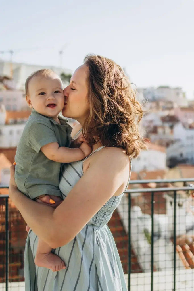 Mother kissing her baby at an Alfama viewpoint
