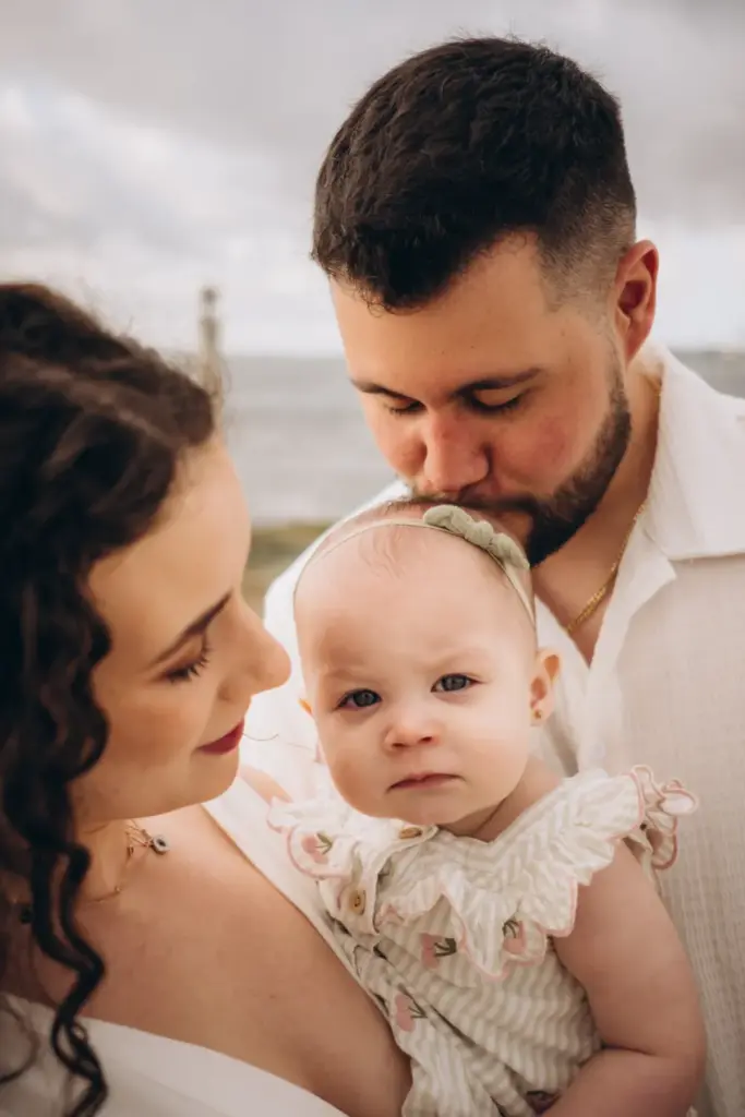 Parents kissing their baby by the river