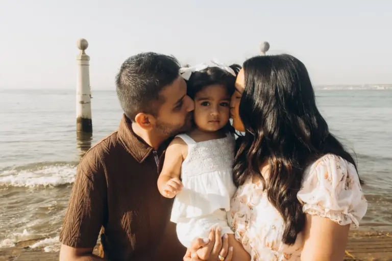 Parents kissing their toddler on the steps of Cais das Colunas