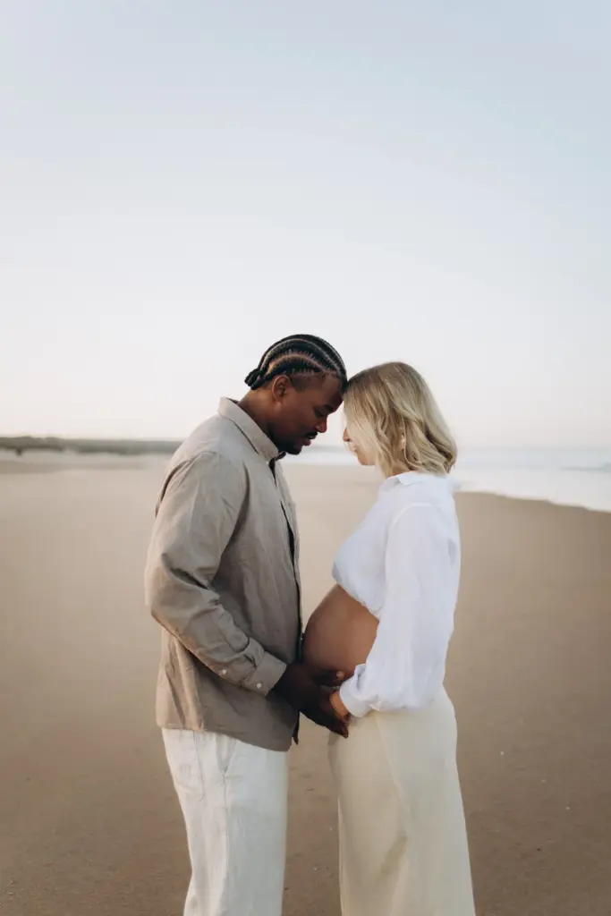 Expecting couple forehead to forehead by the sea
