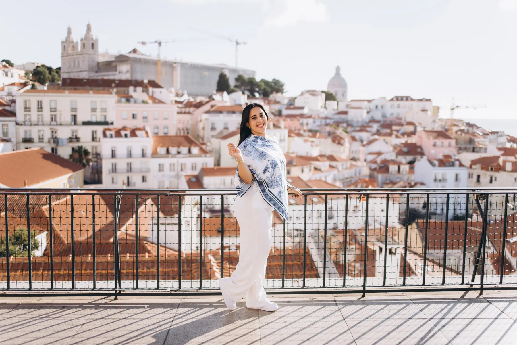 Woman at an Alfama viewpoint over the rooftops