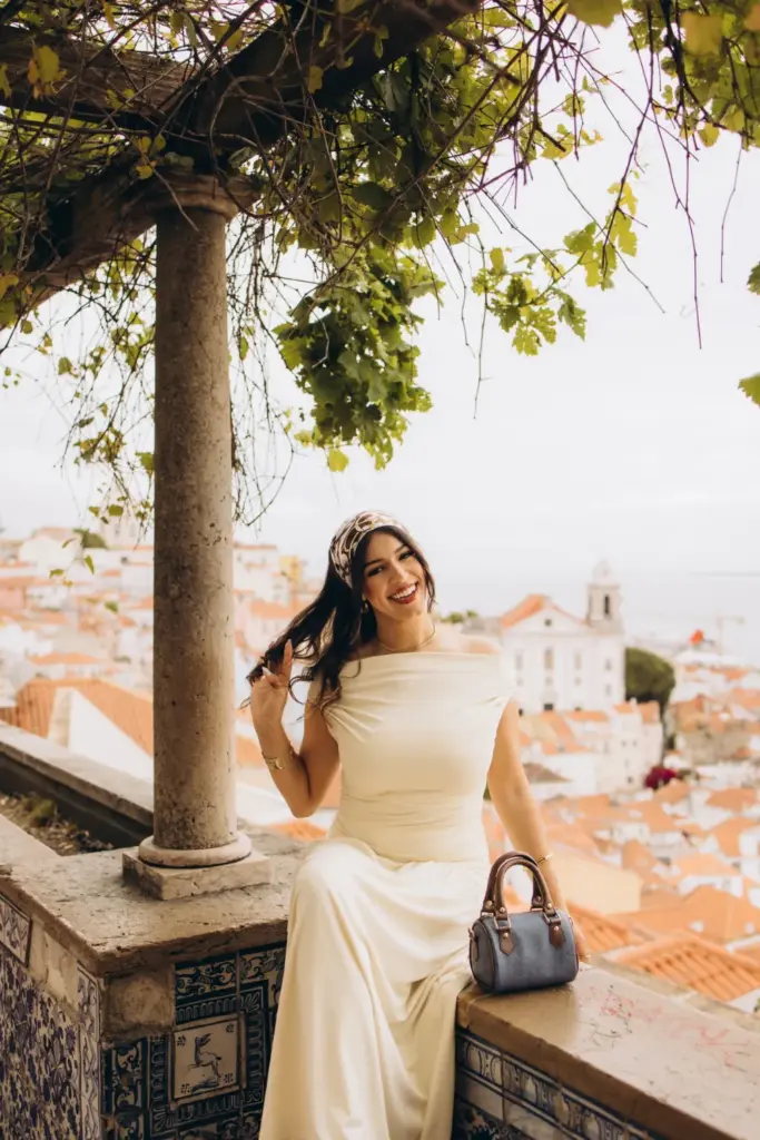 Woman on an azulejo bench under a pergola above Alfama