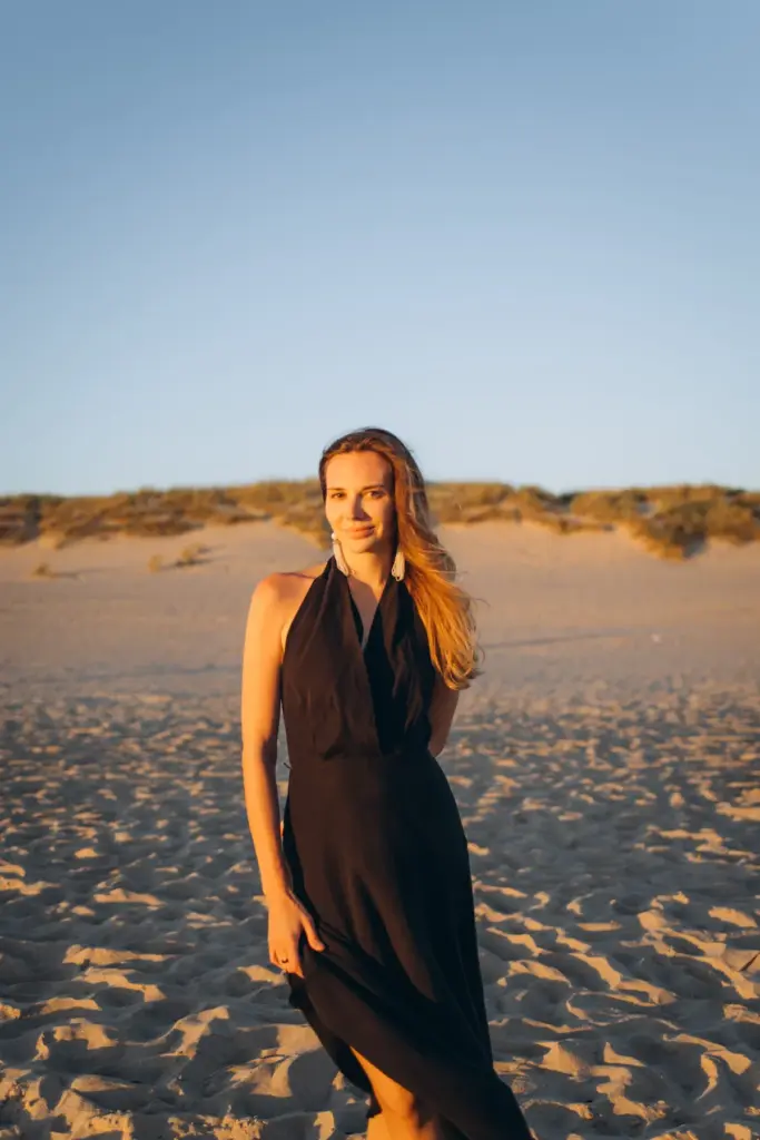 Portrait of a woman on the beach with the dunes behind her