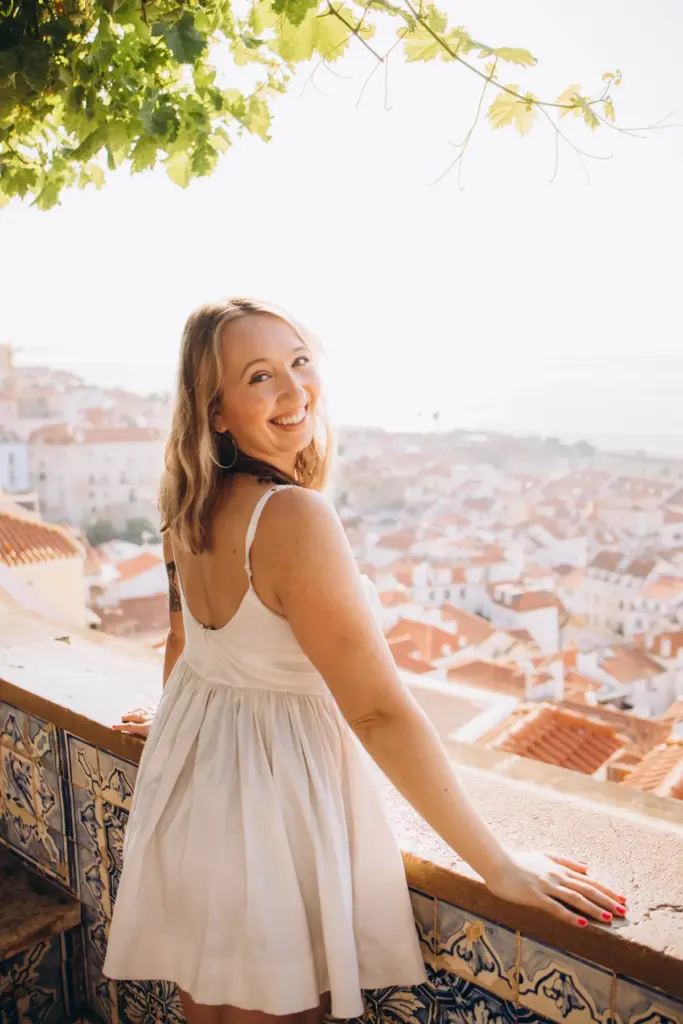 Woman looking back over her shoulder above the rooftops of Alfama
