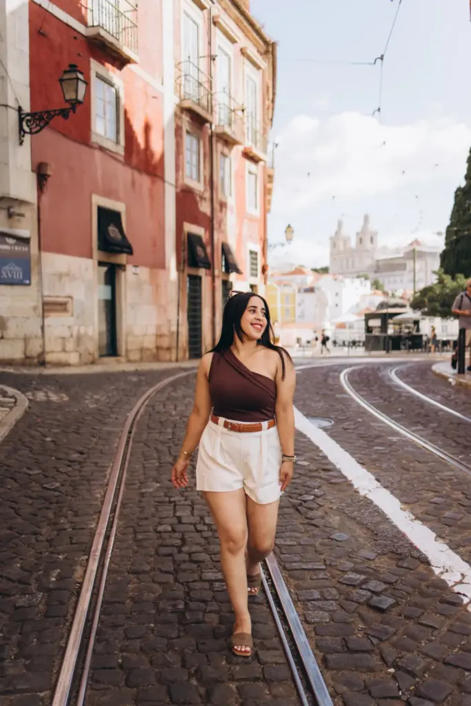 Woman walking down a tram street in Alfama