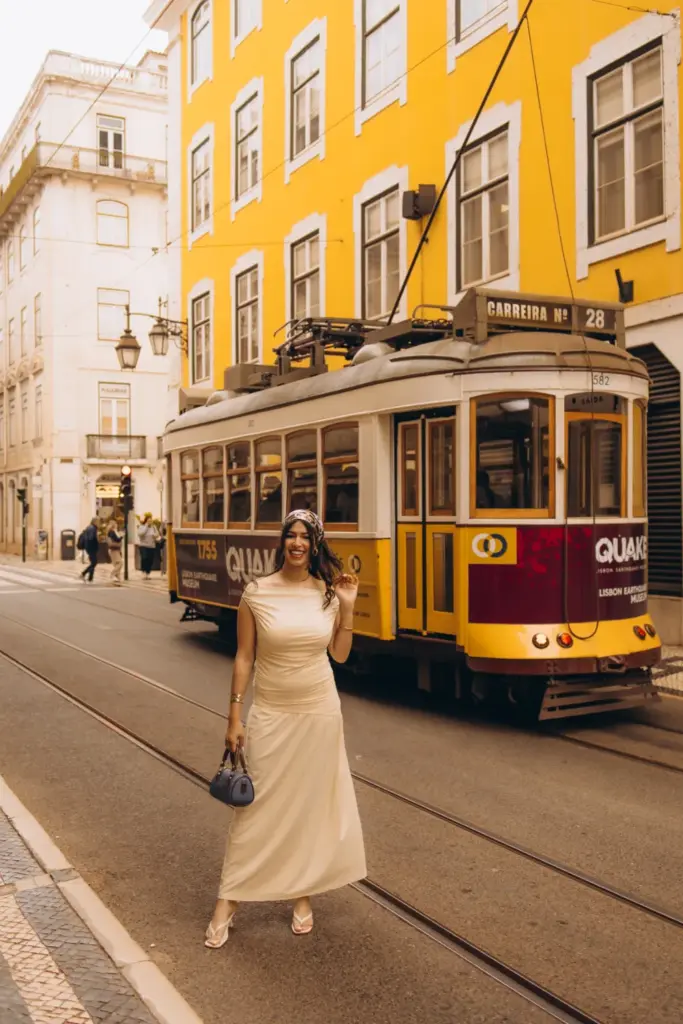 Woman walking beside a yellow tram in Baixa