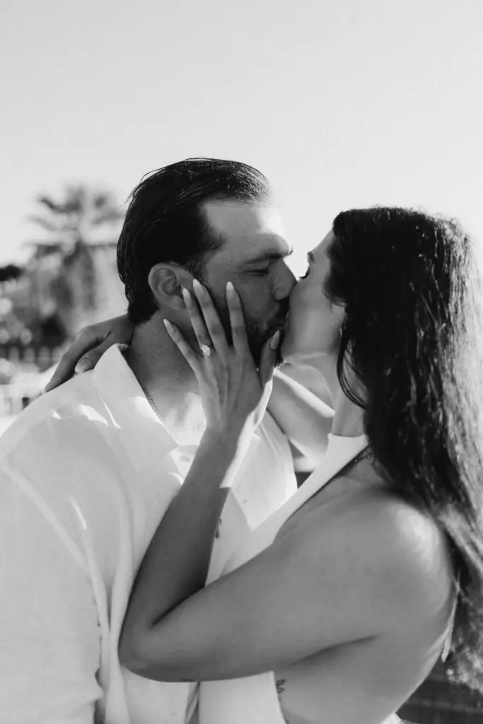 Couple kissing after the proposal, the ring on her hand, black and white