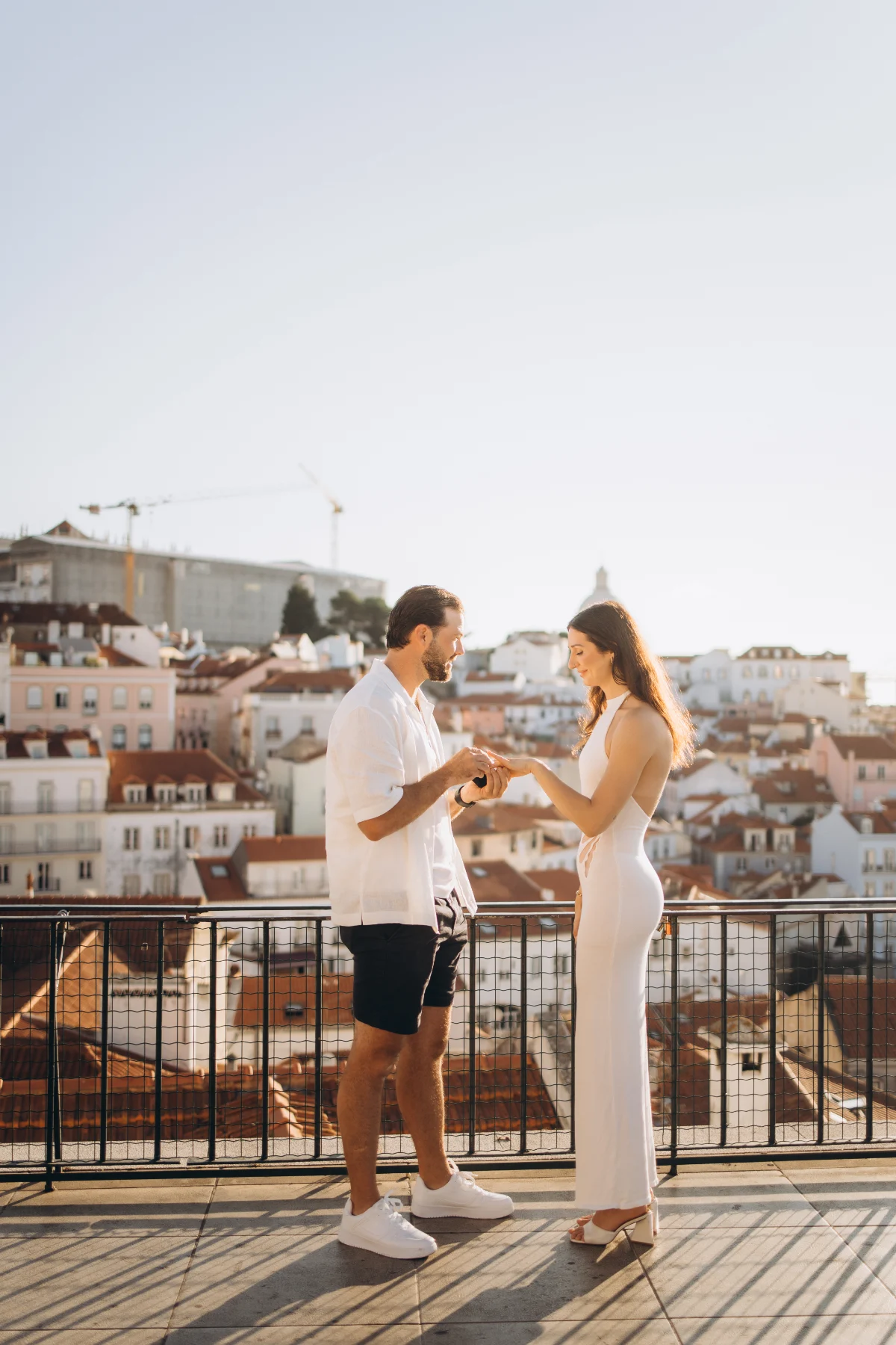 Proposal moment at a Lisbon viewpoint above the Alfama rooftops