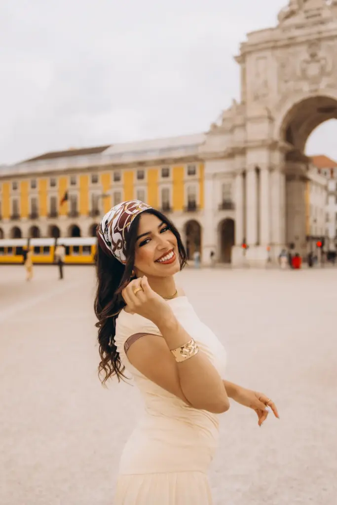 Woman laughing at Praça do Comércio with the arch behind her
