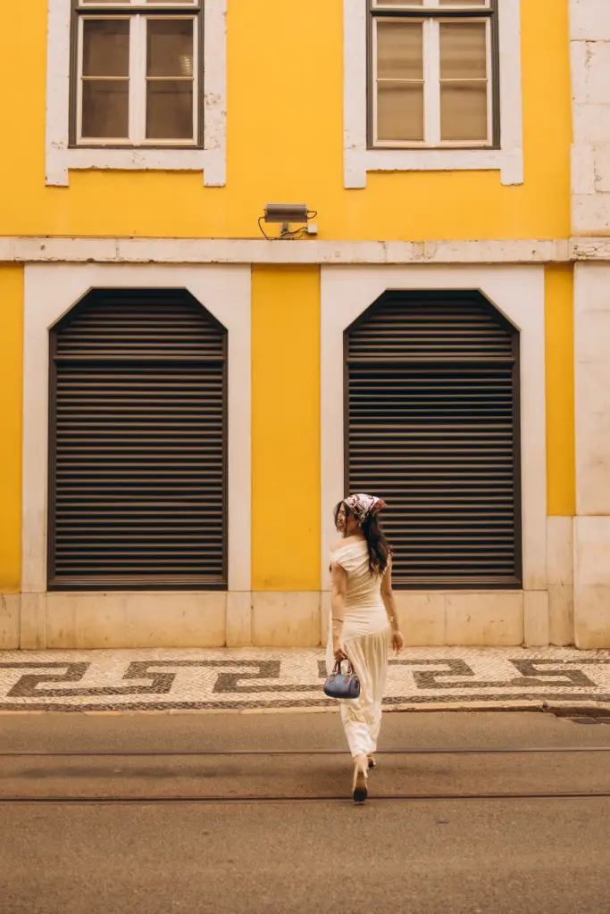 Woman walking past a yellow building in Baixa