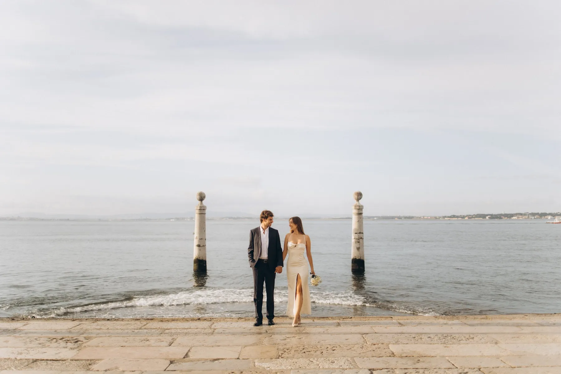 Bride and groom on the Cais das Colunas steps into the Tagus