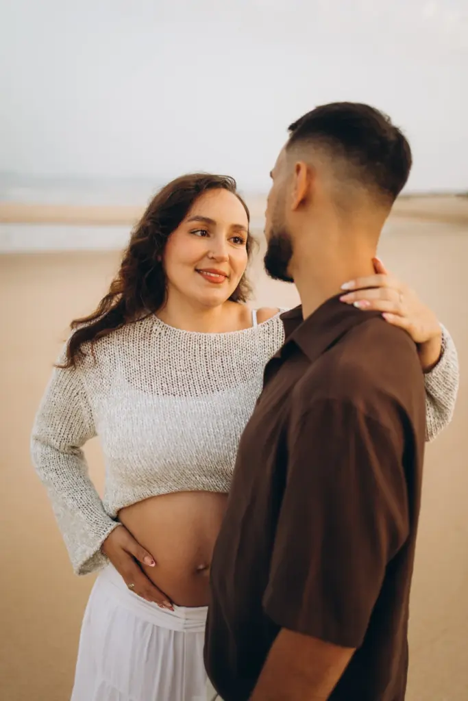 Couple on the sand, the ocean behind them