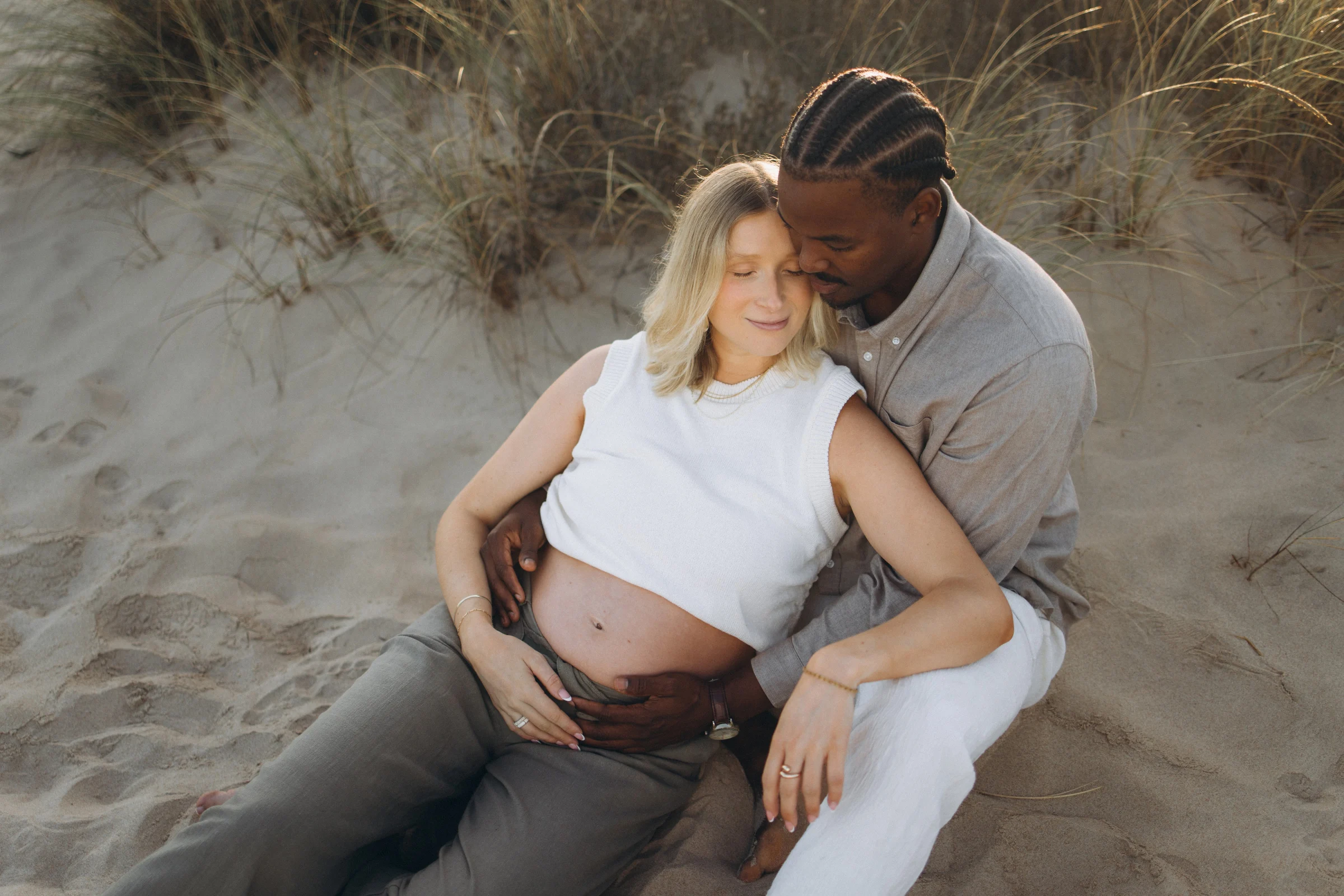 Couple resting in the dunes, her head on his shoulder